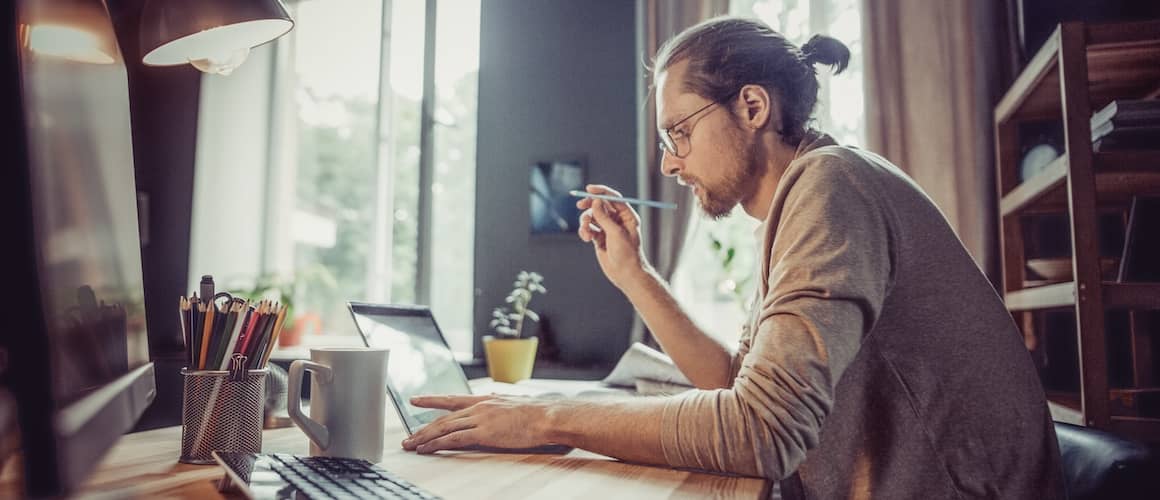 Man with bun working at home office.