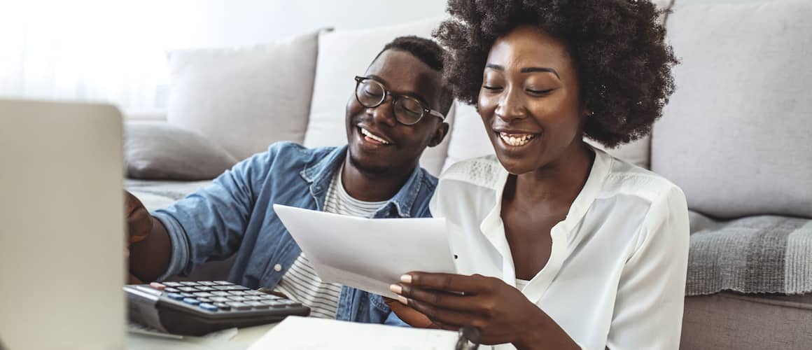 Couple sitting at table doing tax paperwork.