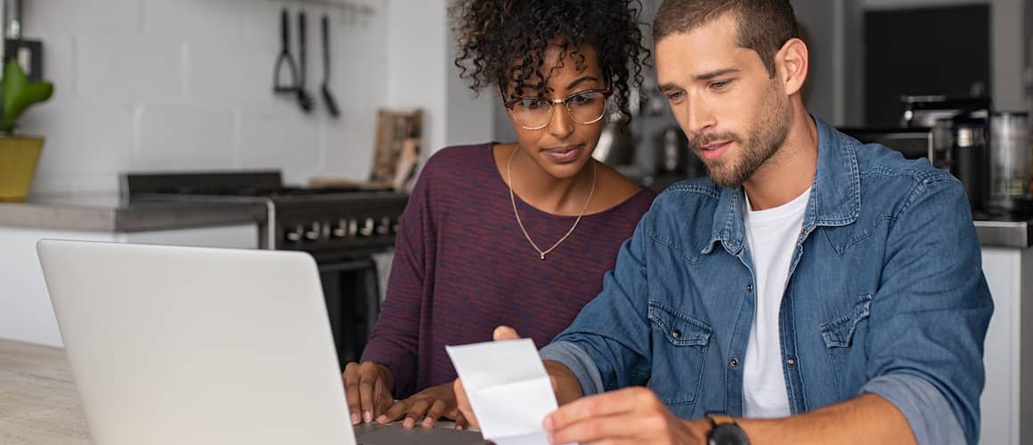 Image of couple in kitchen reviewing debt payments bills.