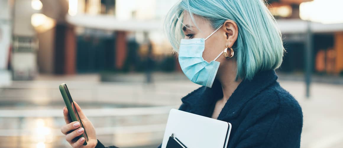 Stock-Woman-With-Light-Blue-Hair-Holding-A-Phone-Wearing-A-Medical-Mask-AdobeStock332458901 copy.jpg