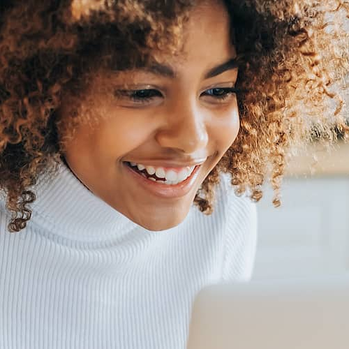 A woman looking possibly looking at her good investments in real estate on laptop.
