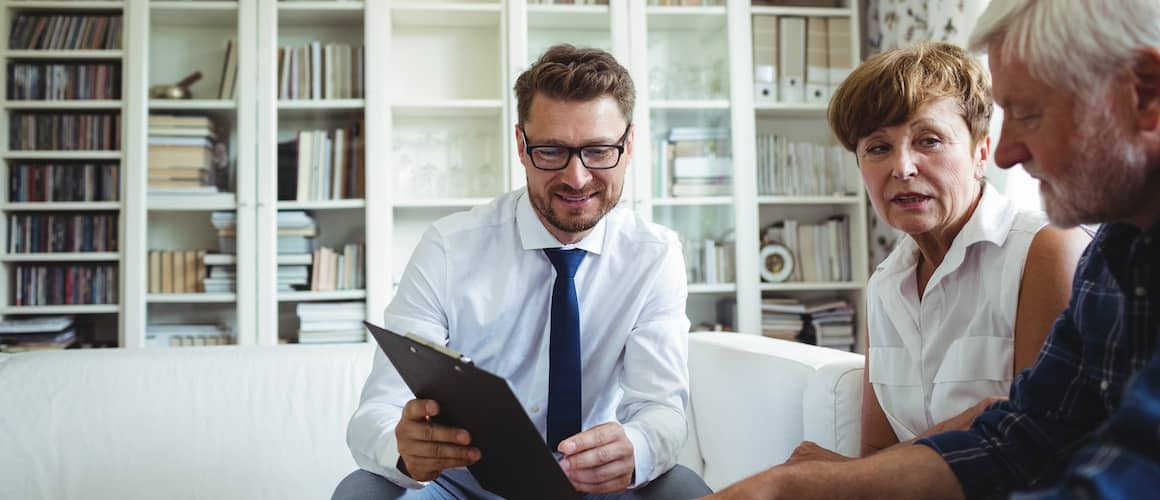 Couple meeting with financial planner on couch in a living room