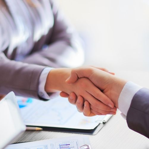 Image illustrating a business handshake, potentially representing a financial agreement or collaboration.