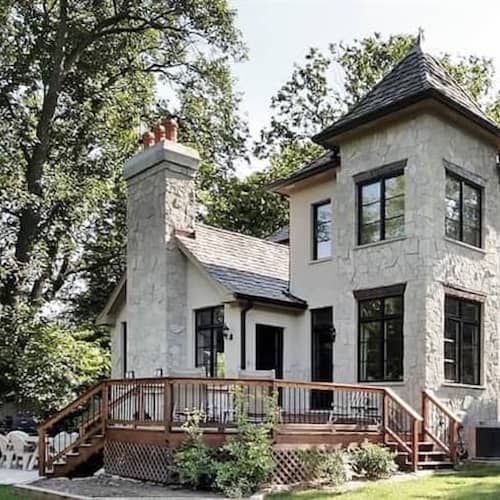 A grand house with a huge yard and deck.