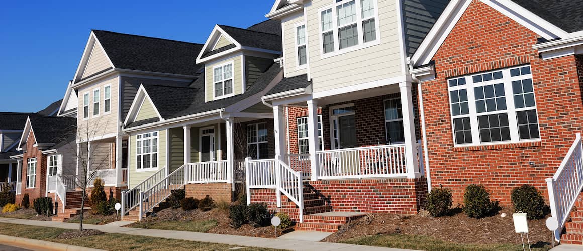 Image displaying a row of townhouses on a sunny day in North Carolina, showcasing real estate or property.