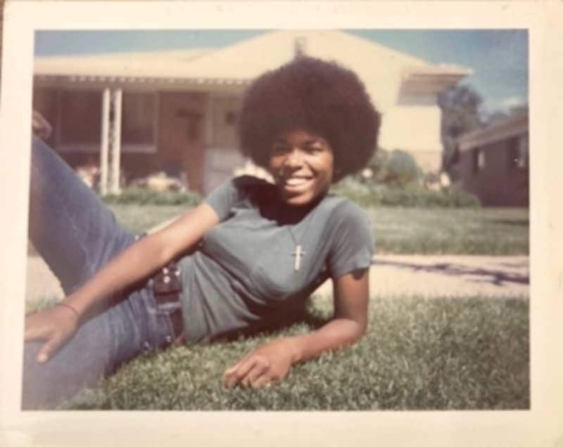 Young woman reclining on a front lawn.