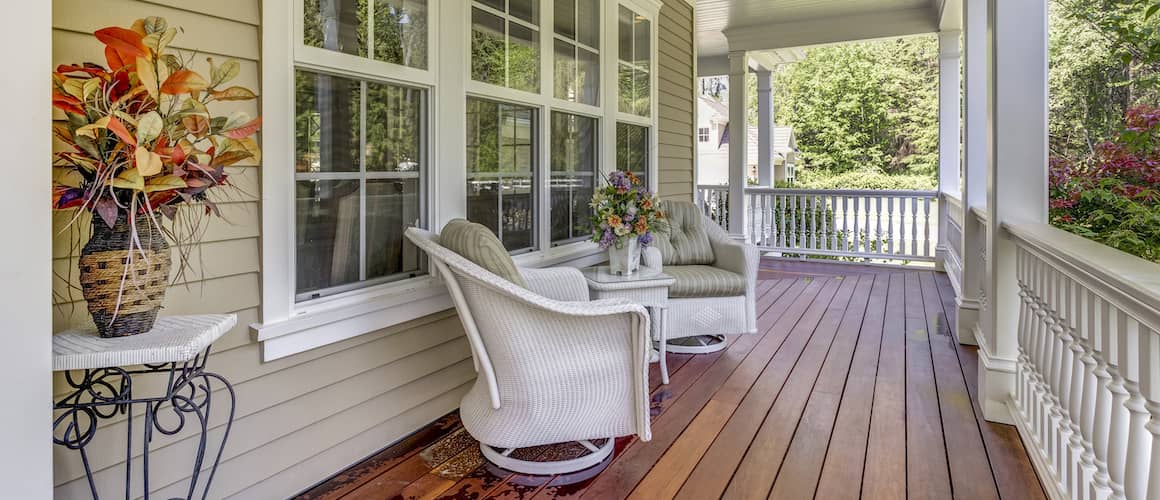 A country-style home with a wrap-around deck, showcasing its exterior and architectural design.