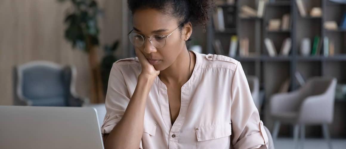 Young woman calculating expenses on a laptop.