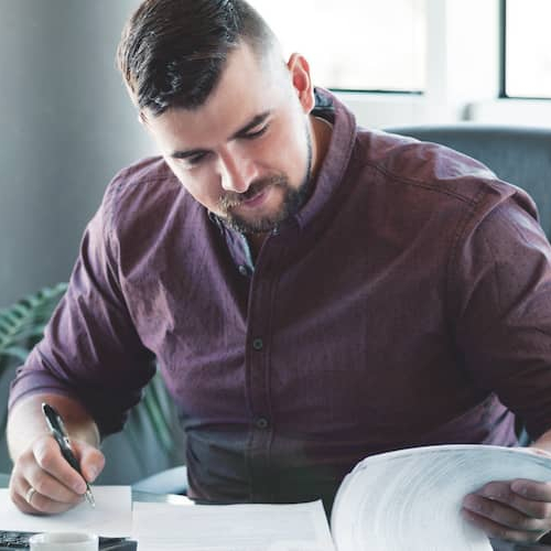 Businessman looking through a binder on his desk in his office.