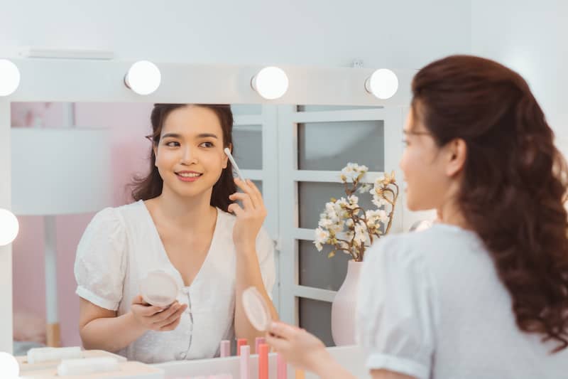 RHB Assets From IGX: Elegant woman at a vanity in a spacious walk-in closet.