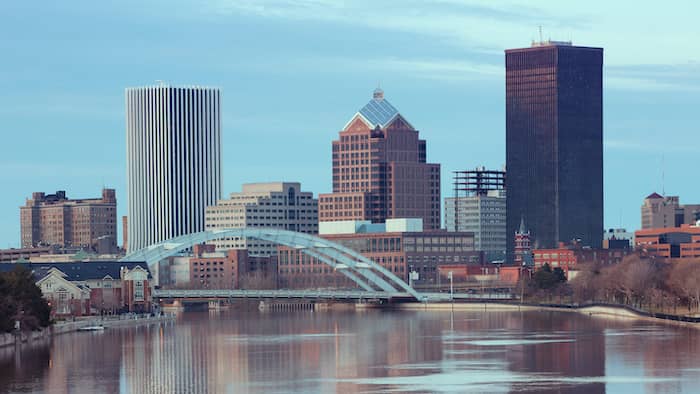 RHB Assets From IGX: Rochester, New York skyline at sunset with buildings reflecting on the water.