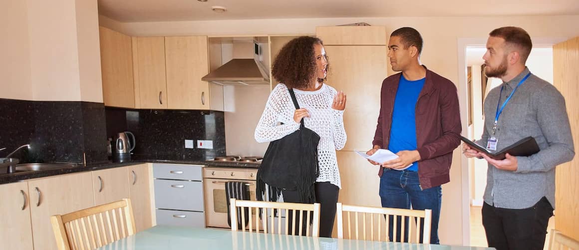 Agent showing house to couple in kitchen.