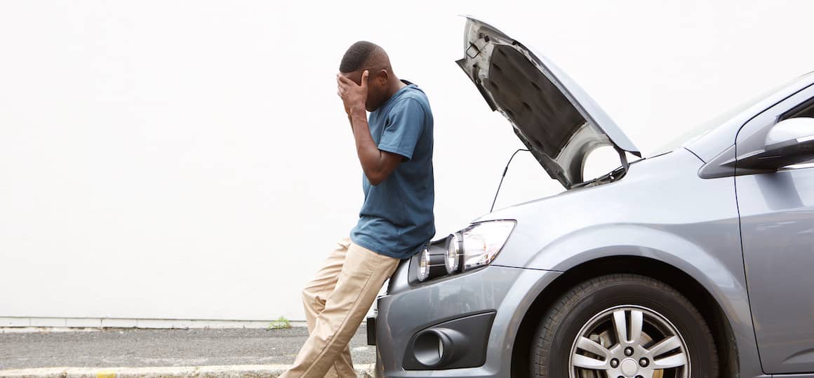 Man frustrated with broken down car.