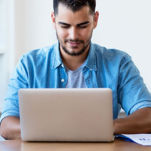 A man researching on a computer, likely conducting real estate or financial research online.
