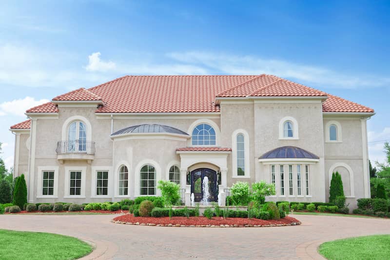 Front view of mansion with a fountain near the entrance.