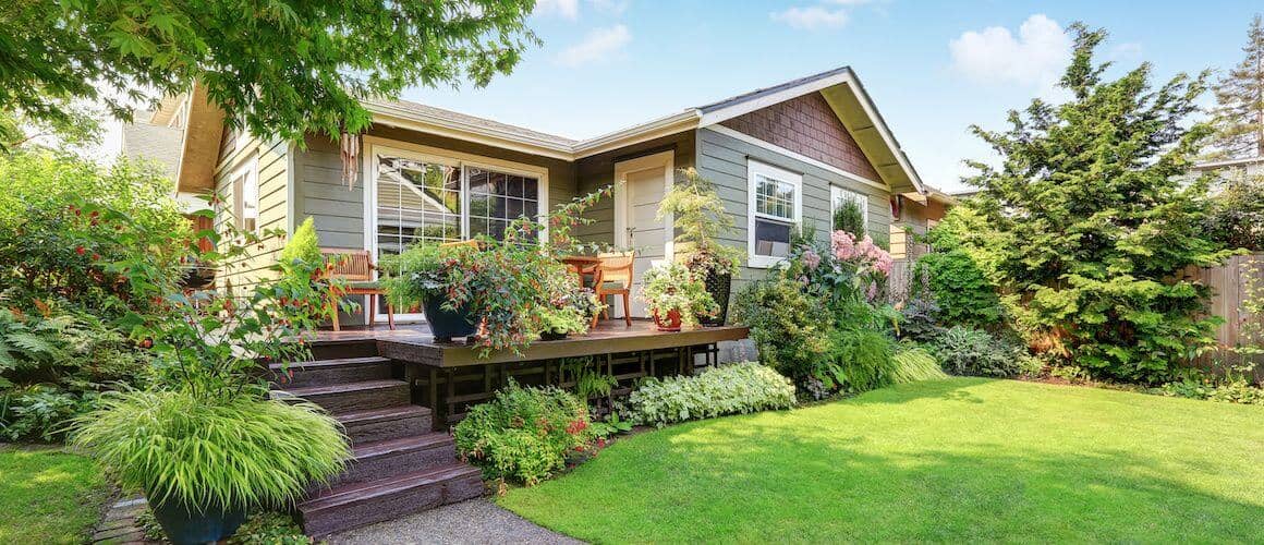 A cozy house with a charming garden and a lovely deck, perfect for relaxation and outdoor gatherings.