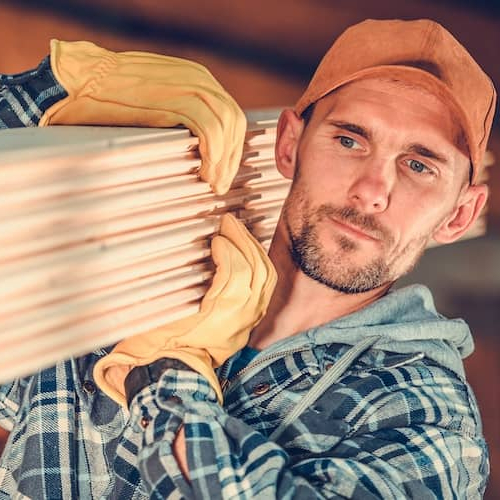 RHB Assets From IGX: A person carrying lumber for a construction project.