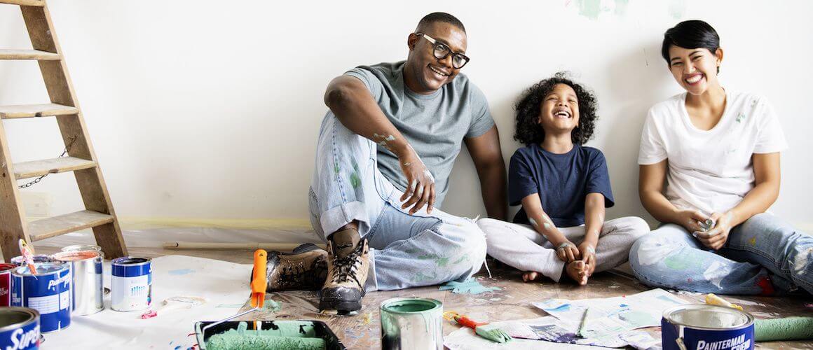 Family engaging in a painting activity, possibly related to home improvement or creative bonding.