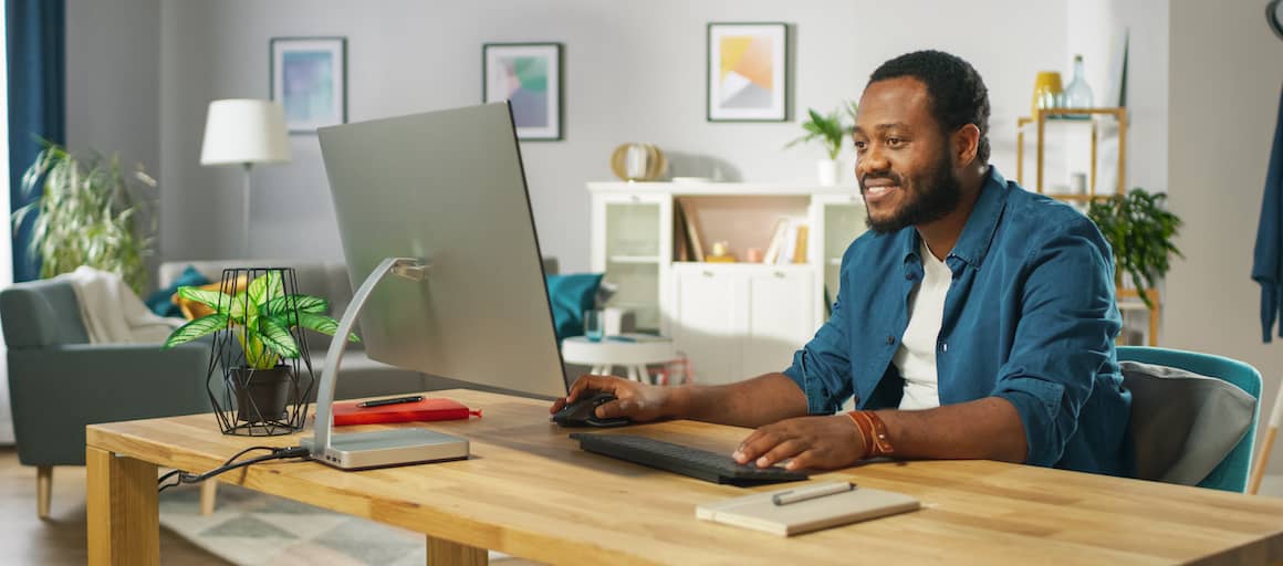 A man working on a desktop computer, potentially managing finances or researching mortgage-related information.