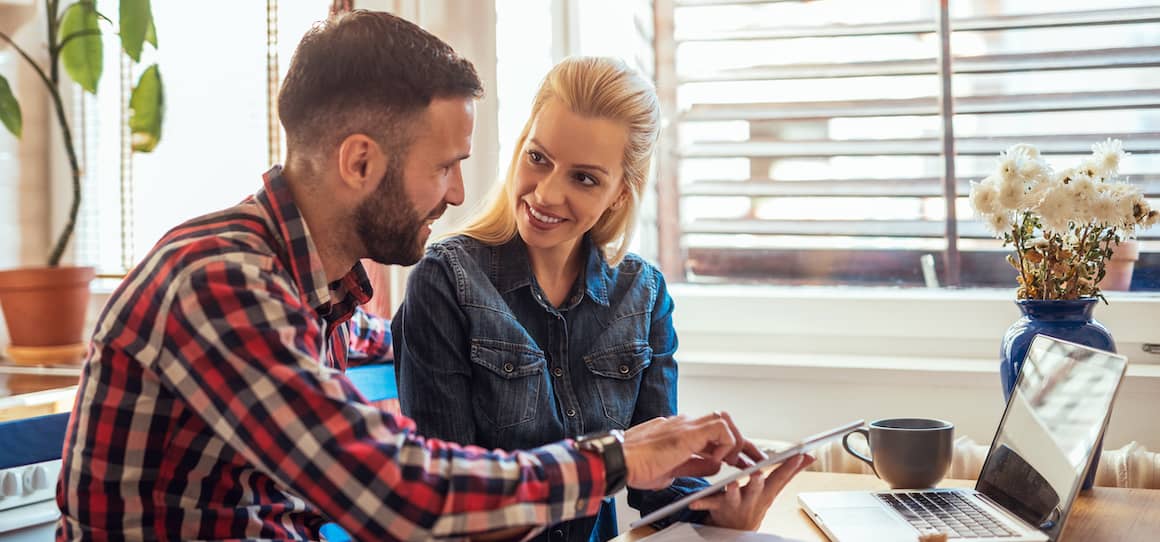 RHB Assets From IGX: Couple working from home on their laptops, sitting on a couch