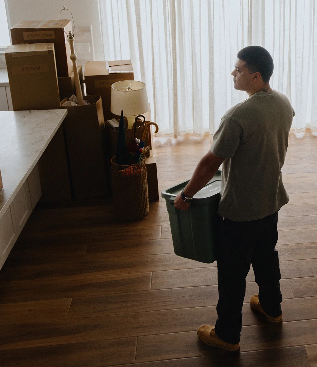A veteran who used his VA loan benefit with Rocket Mortgage carries a moving box into his new home.