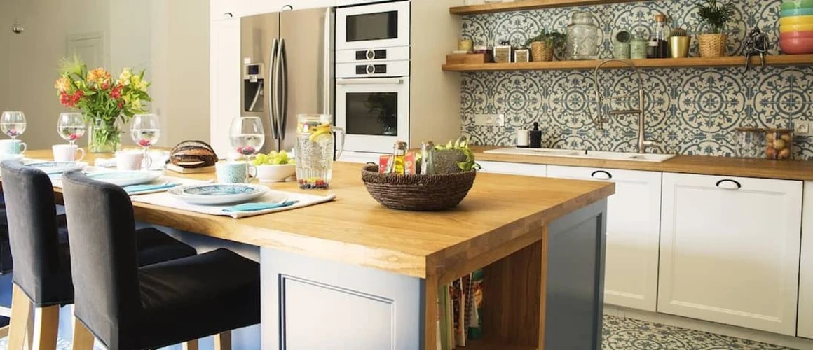 Interior de una cocina con una gran isla y protector contra salpicaduras de mosaicos.