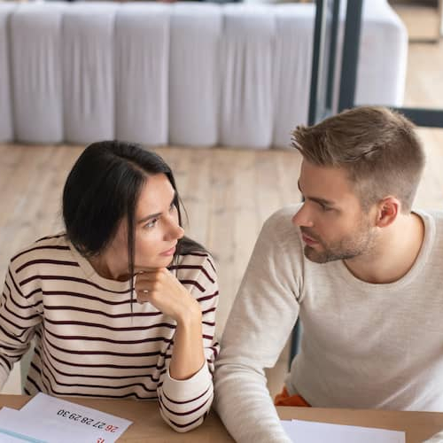 A couple having a discussion, potentially about new home prospects.