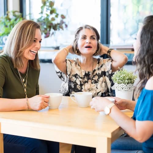 Multigenerationl trio of women chatting and having coffee.
