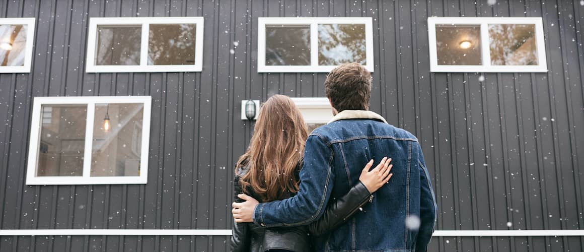 A couple looking towards a house possibly the one they just bought and thinking of starting a new chapter in it.