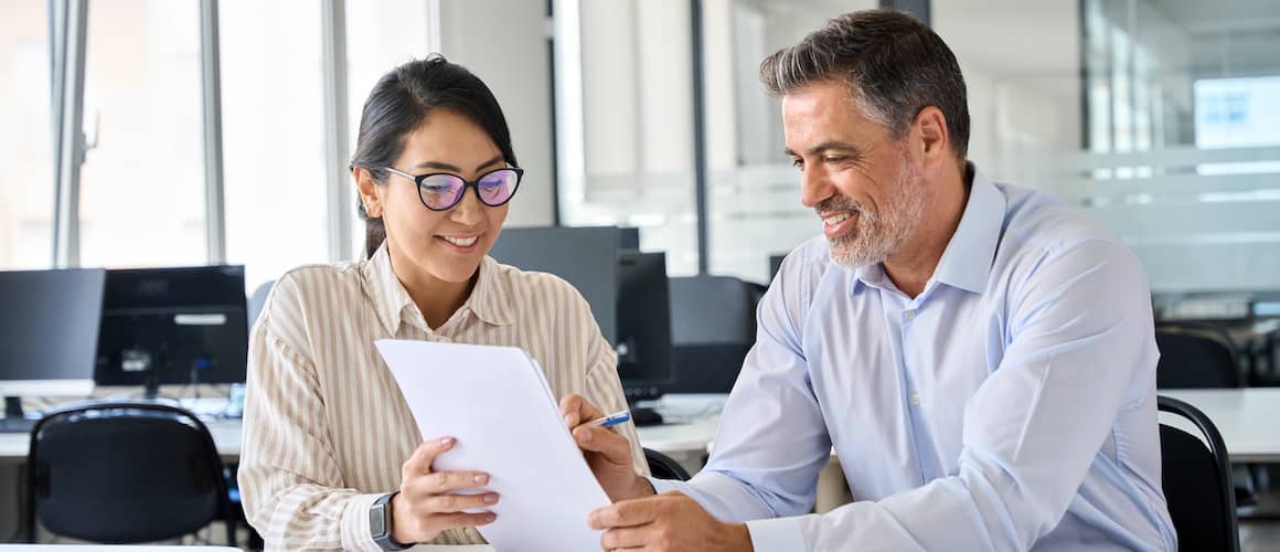 An account advisor showing papers to a client, indicating a professional interaction or financial consultation.