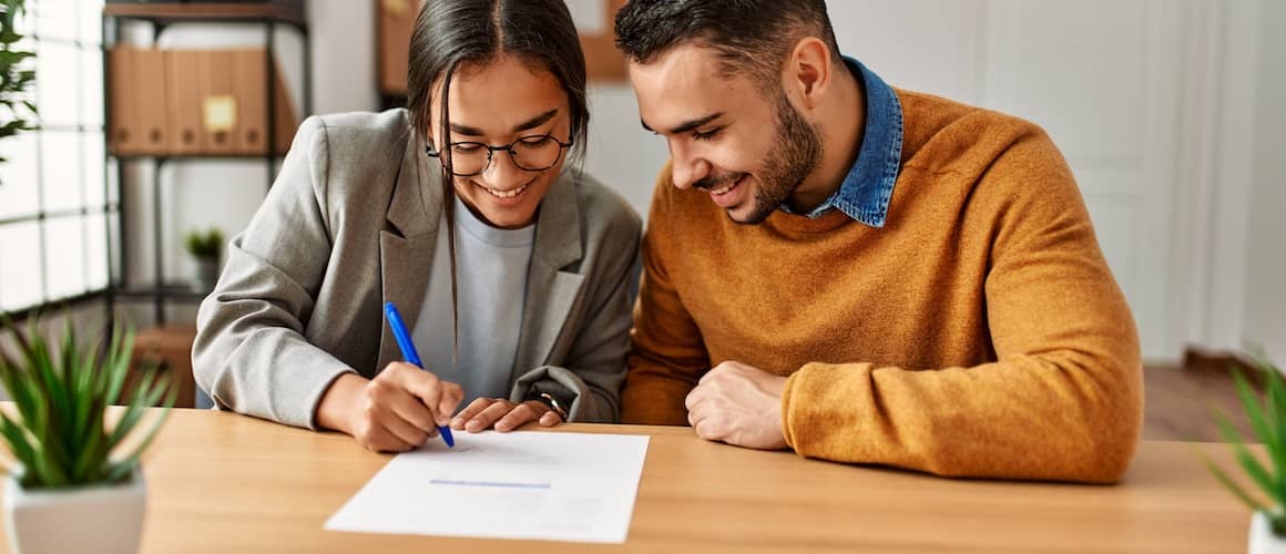 Man and woman reviewing a contract together before signing.