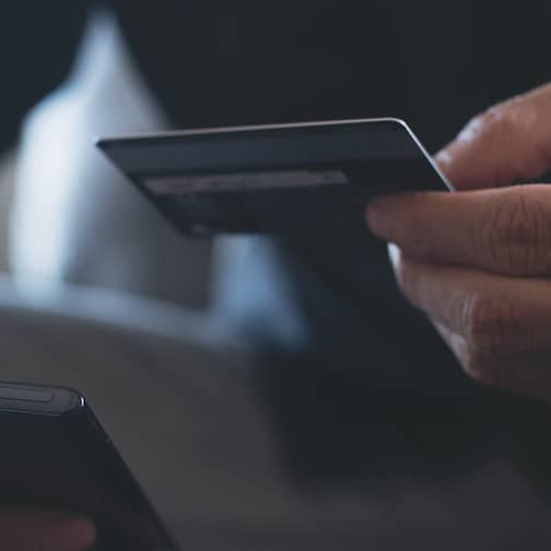A man with a credit card, potentially symbolizing financial transactions or purchases related to homeownership.