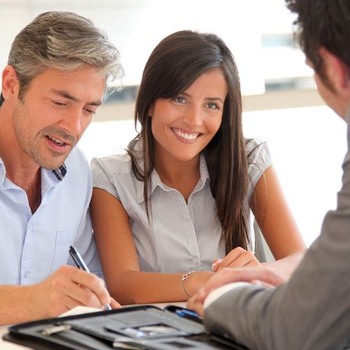 A couple discussing finances or mortgages with an agent.