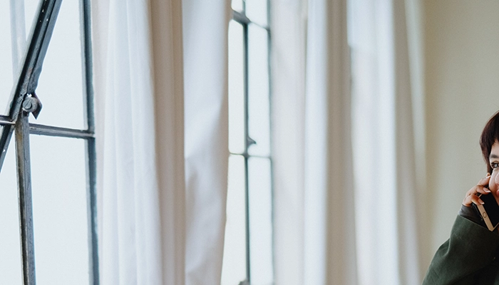 Woman on the phone looking out window.