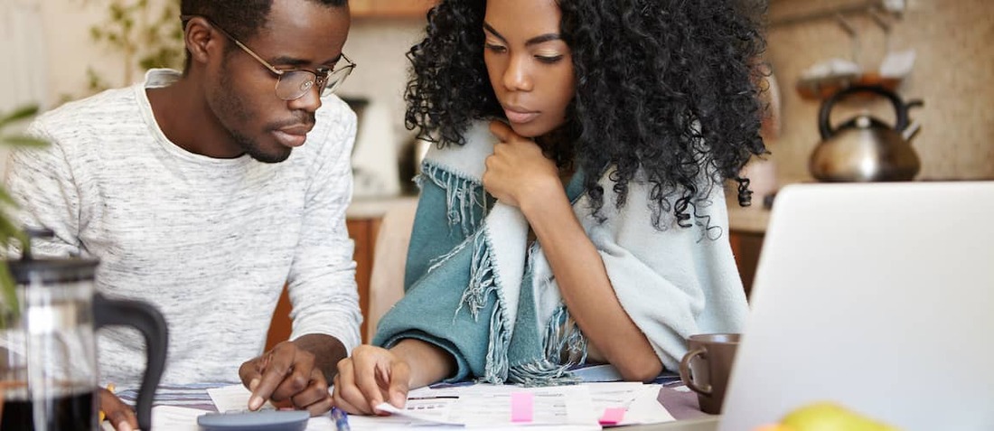 Young African-American couple working on budget together.