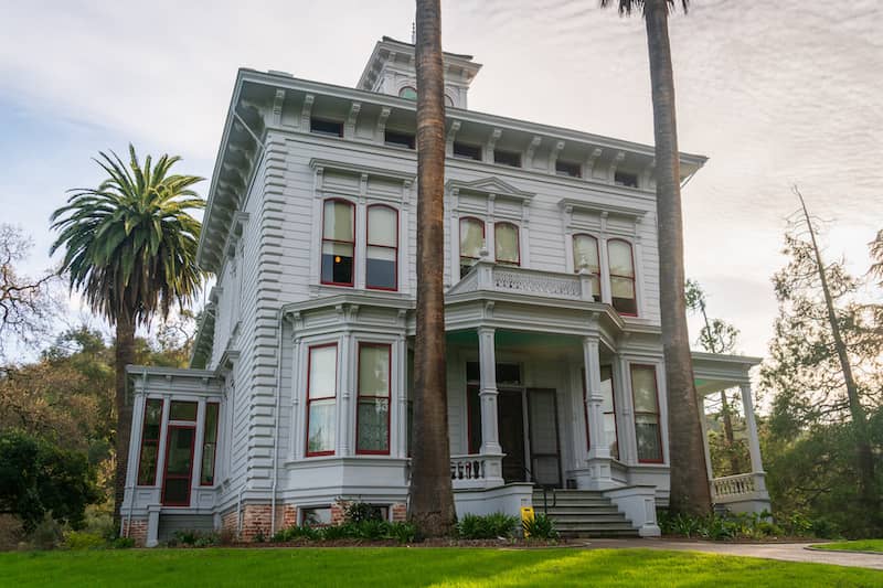 Front view of a white two story Italianate home with ornate trim.