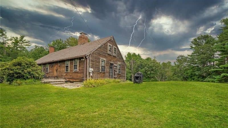 The Conjuring House under a stormy sky.