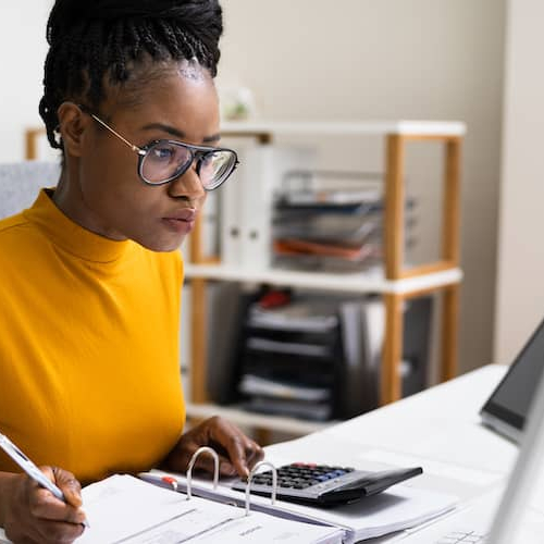 A person in a yellow shirt working on taxes, possibly related to homeownership or property taxes.